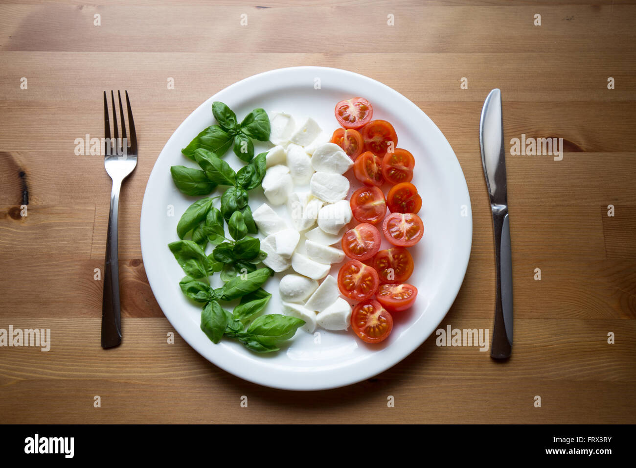 L'Italie sur une assiette. Les meilleurs ingrédients : Basilic, mozzarella et tomates cerises, représentant également les couleurs du drapeau de l'Italie. Banque D'Images