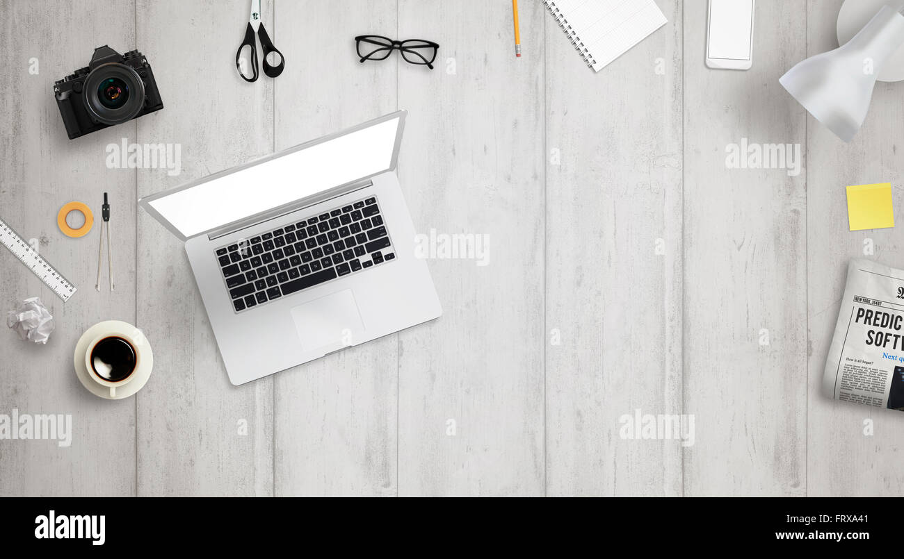 Bureau avec ordinateur portable et de l'espace libre pour le texte entouré avec beaucoup d'accessoires de bureau. Il y a un téléphone, appareil photo, café, verre Banque D'Images