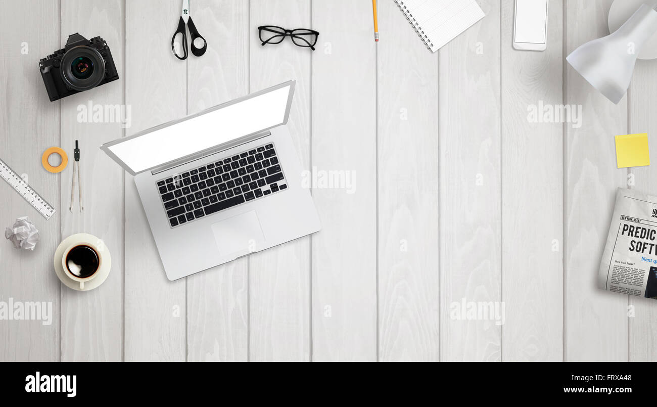 Bureau avec ordinateur portable et de l'espace libre pour le texte entouré avec beaucoup d'accessoires de bureau. Il y a un téléphone, appareil photo, café, verre Banque D'Images