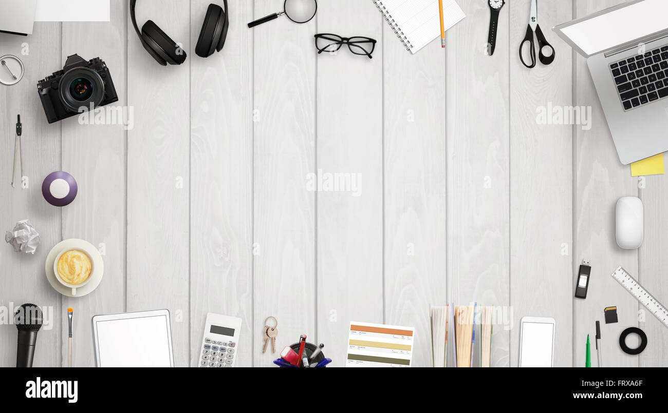 Bureau de travail avec espace libre pour le texte entouré avec beaucoup d'accessoires de bureau. Il y a un ordinateur portable, tablette, téléphone, appareil photo, casque, Banque D'Images