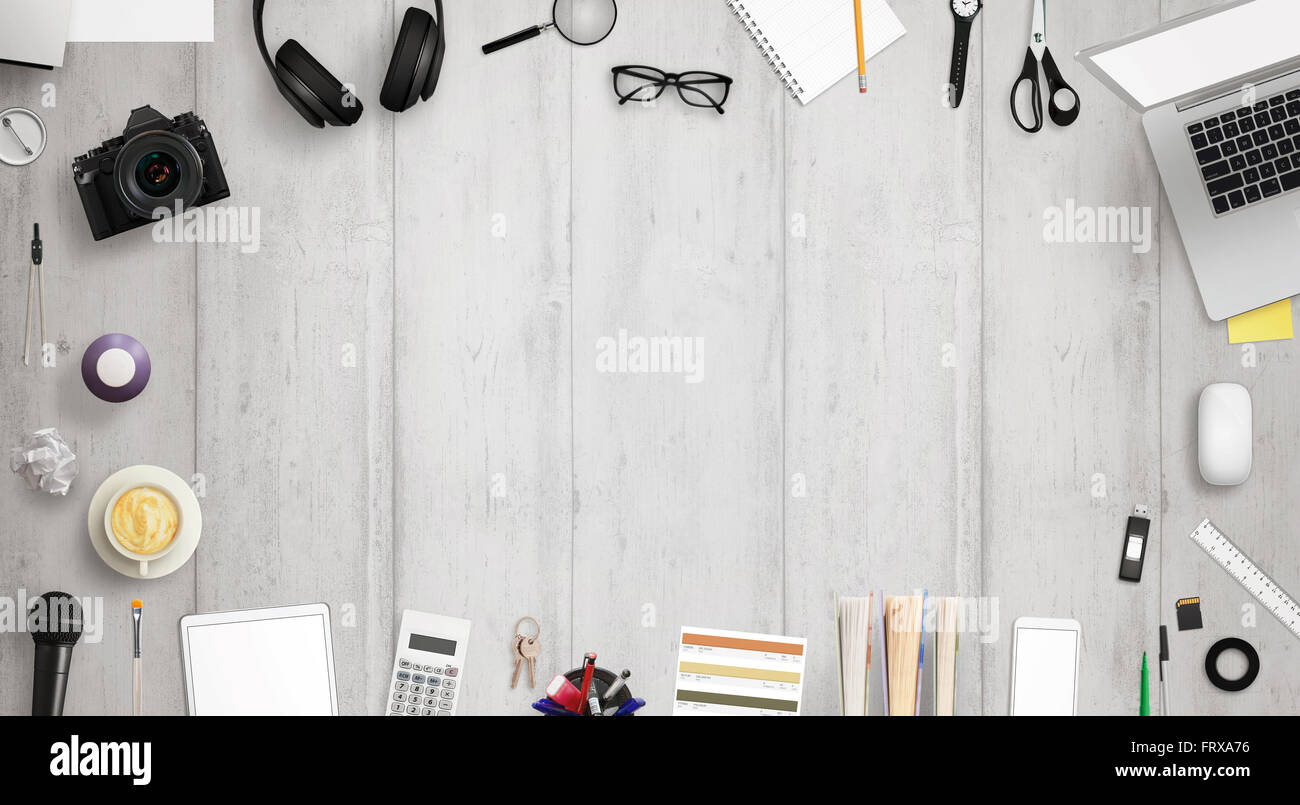 Bureau de travail avec espace libre pour le texte entouré avec beaucoup d'accessoires de bureau. Il y a un ordinateur portable, tablette, téléphone, appareil photo, casque, Banque D'Images