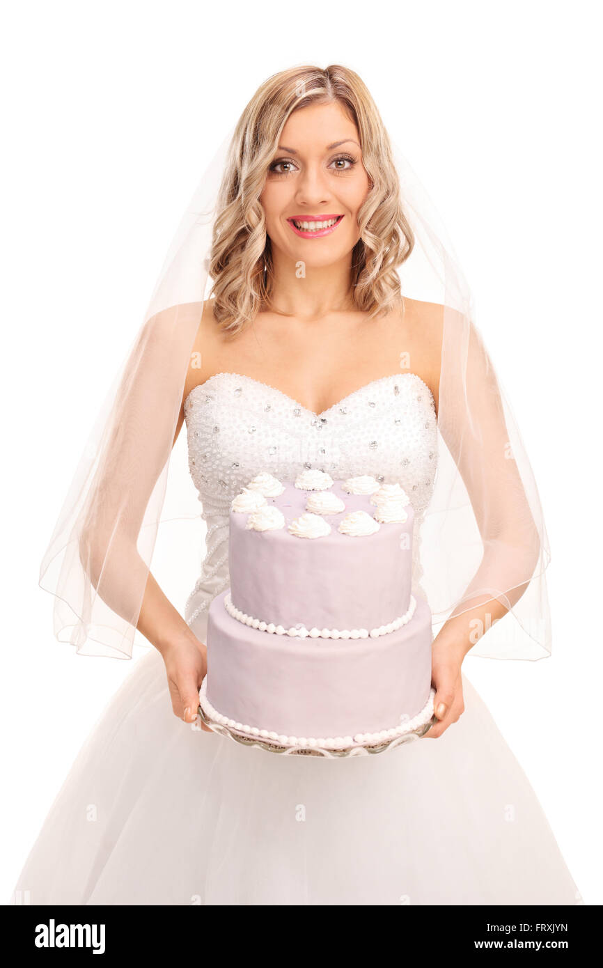 Shot verticale d'une jeune blonde bride portant un gâteau de mariage et regardant la caméra isolé sur fond blanc Banque D'Images