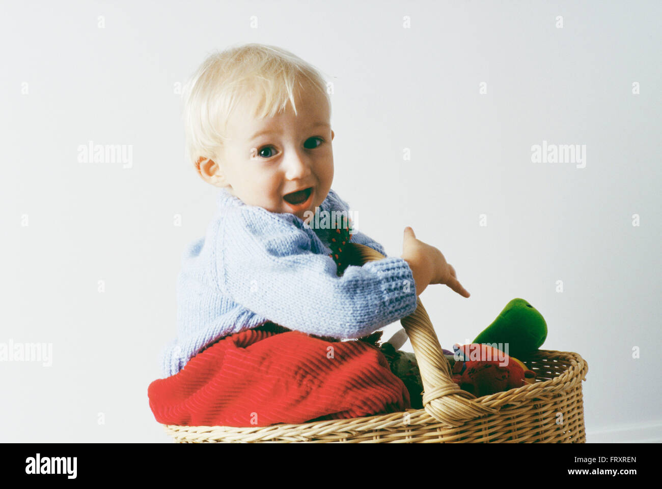 Portrait d'un garçon âgé d'un an assis dans un panier Banque D'Images