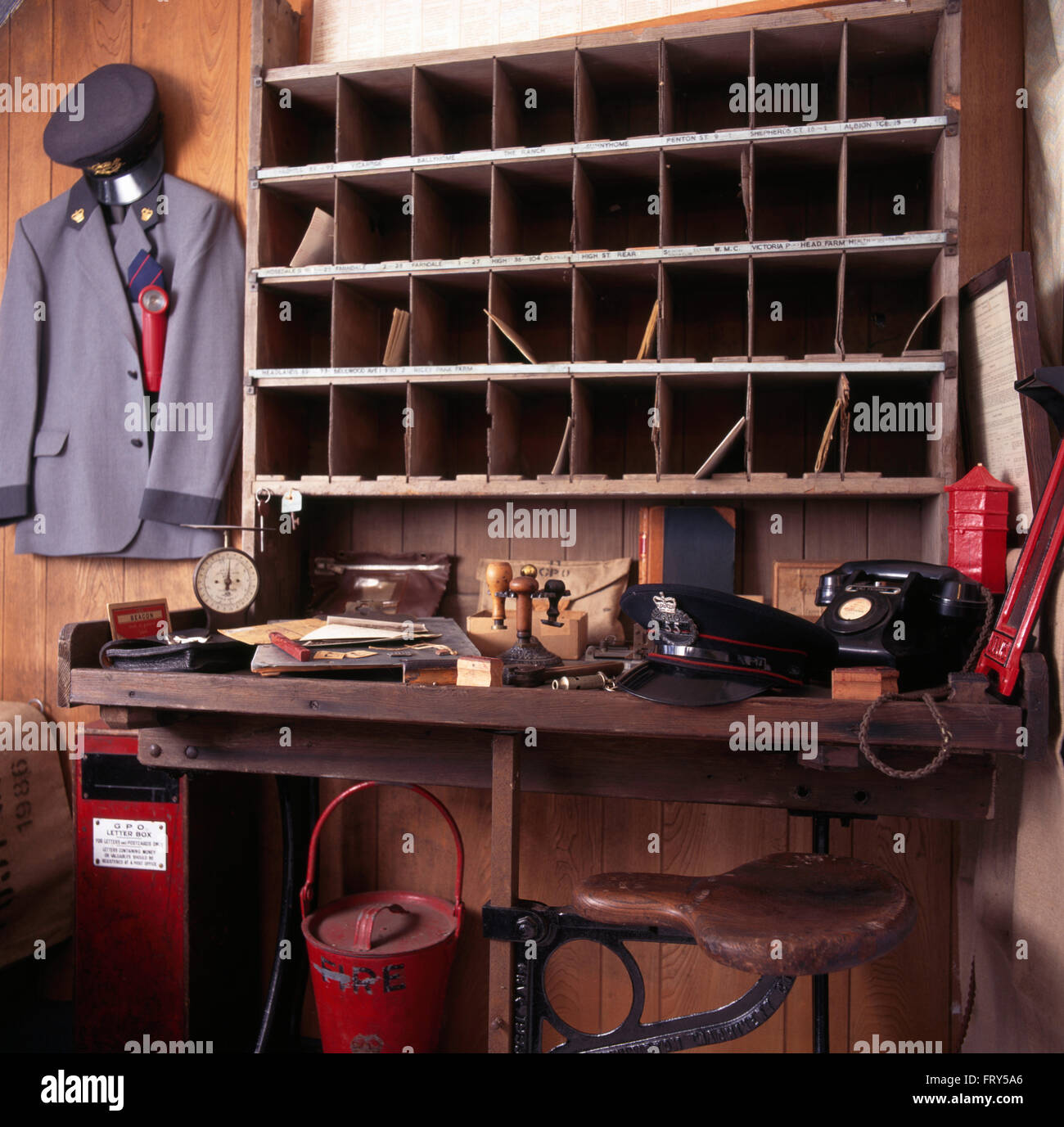 Le tableau ci-dessous téléphone Vintage casier étagères dans années 40 avec l'étude un uniforme accroché au mur Banque D'Images
