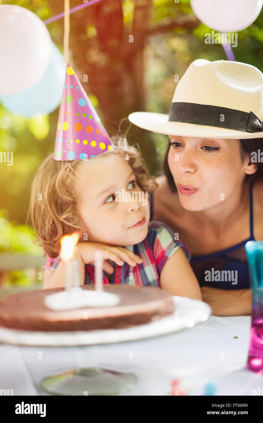Garden Party Avec Maman Pour L Anniversaire De Petite Fille Les Enfants Souffle Les Bougies Sur Le Gateau Le Jardin Est Decoree Avec Des Ballons Et Les Couleurs Sont Lumineuses Photo Stock