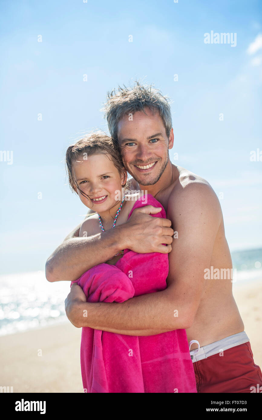 Papa à la plage enveloppant sa petite fille dans une serviette après bain  Photo Stock - Alamy