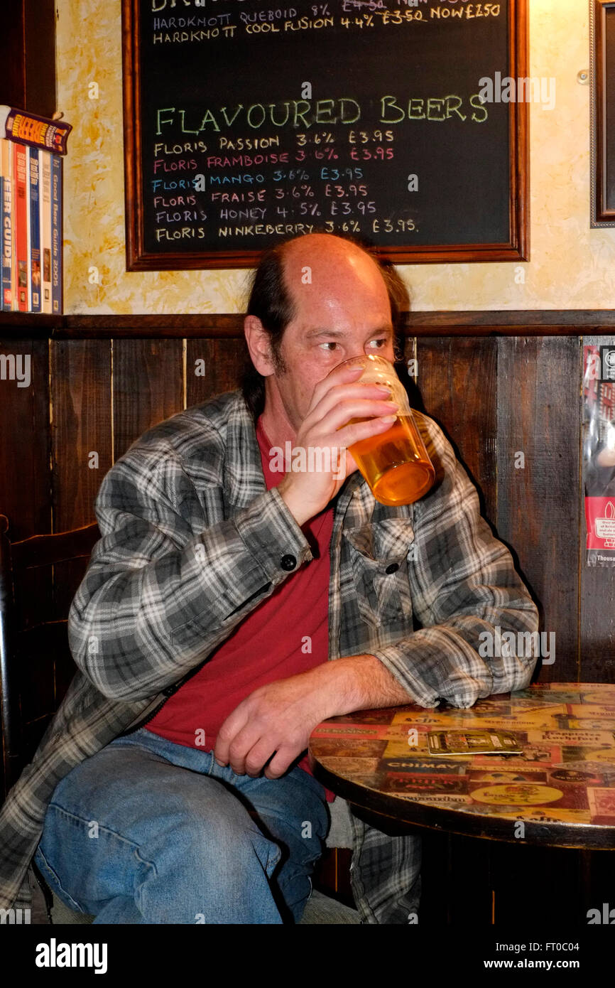 Mâle mature à boire une pinte d'ale réel en pub bar le trou dans le mur uk angleterre southsea Banque D'Images