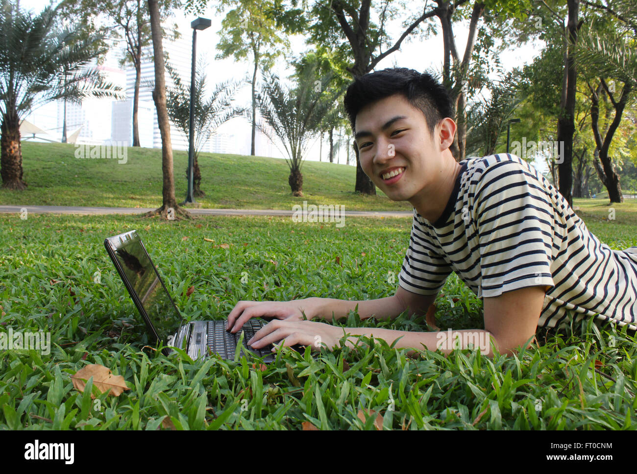 Jeune homme avec l'ordinateur, dans le parc Banque D'Images