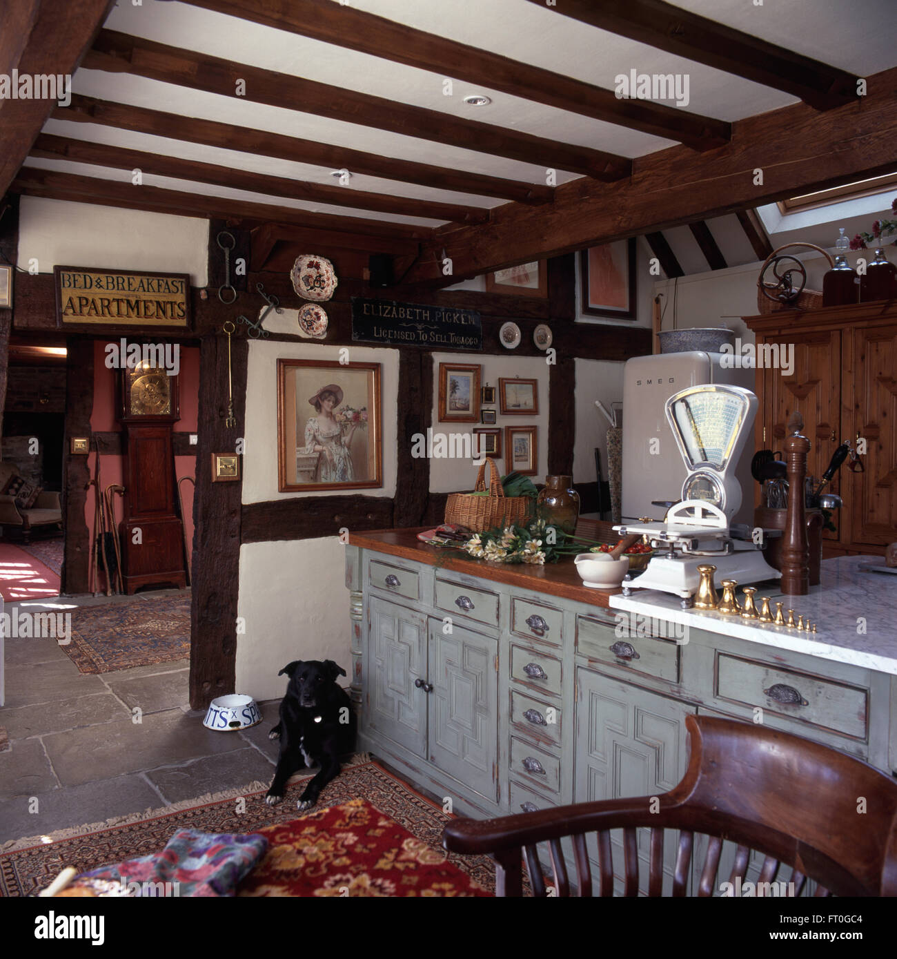 Chien couché à côté de la chaux dans les unités lavées 90 cuisine de campagne avec un grand poids sur les balances et rétro haut travail Banque D'Images