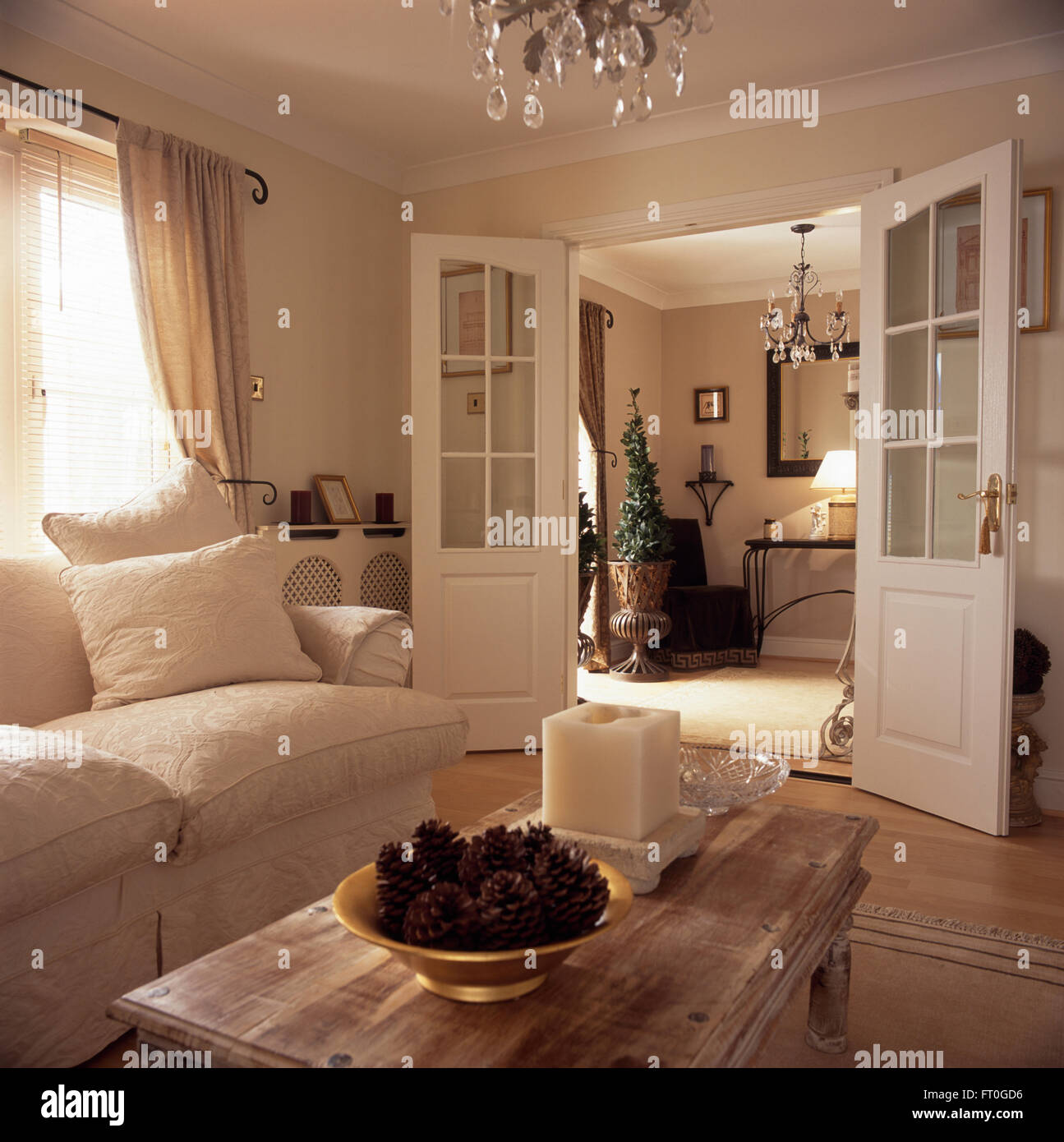 Canapé Blanc et citron vert lavé une table basse dans un salon des années 90 avec demi-portes vitrées ouvertes à la salle Banque D'Images