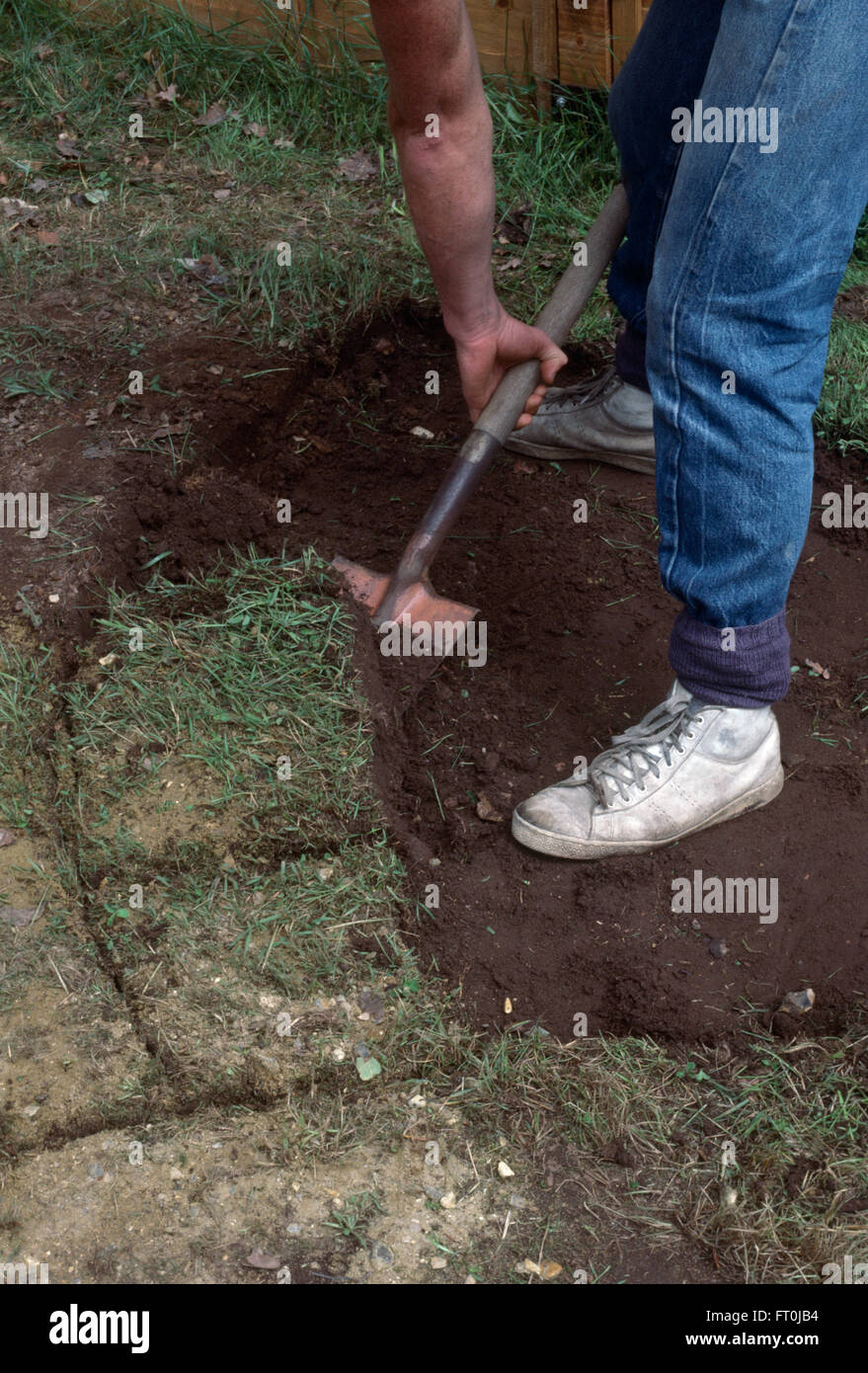 Close-up d'un jardinier creuser vers le haut avant la pose du gazon paving Banque D'Images