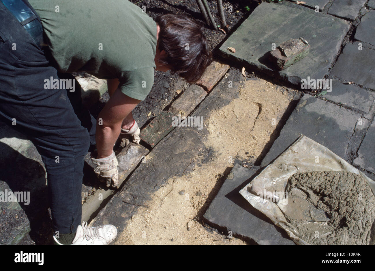 Close-up of a woman remplacement pavage fissuré sur un patio pour un usage éditorial uniquement Banque D'Images