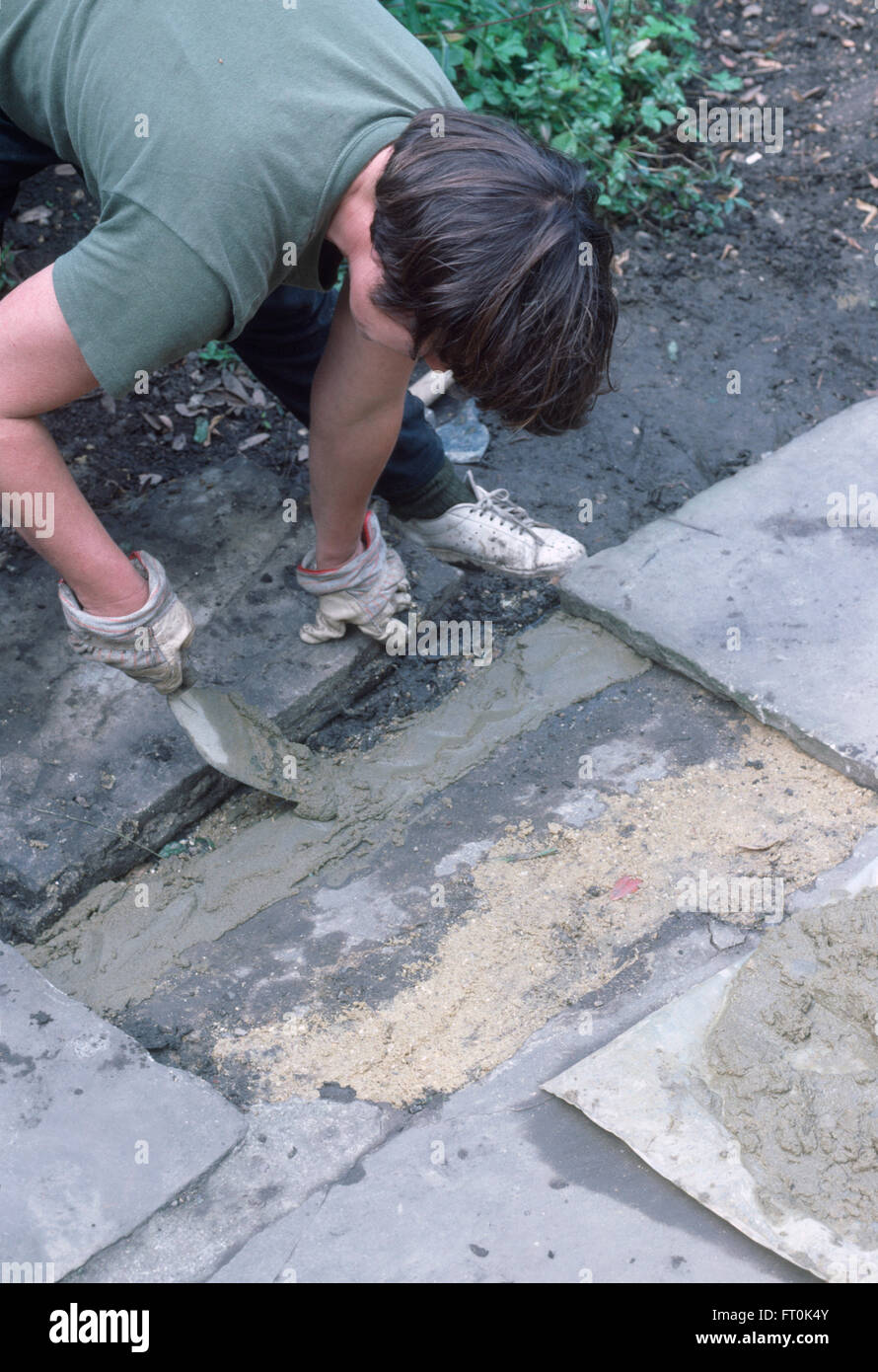 Close-up of a woman remplacement pavage fissuré sur un patio pour un usage éditorial uniquement Banque D'Images