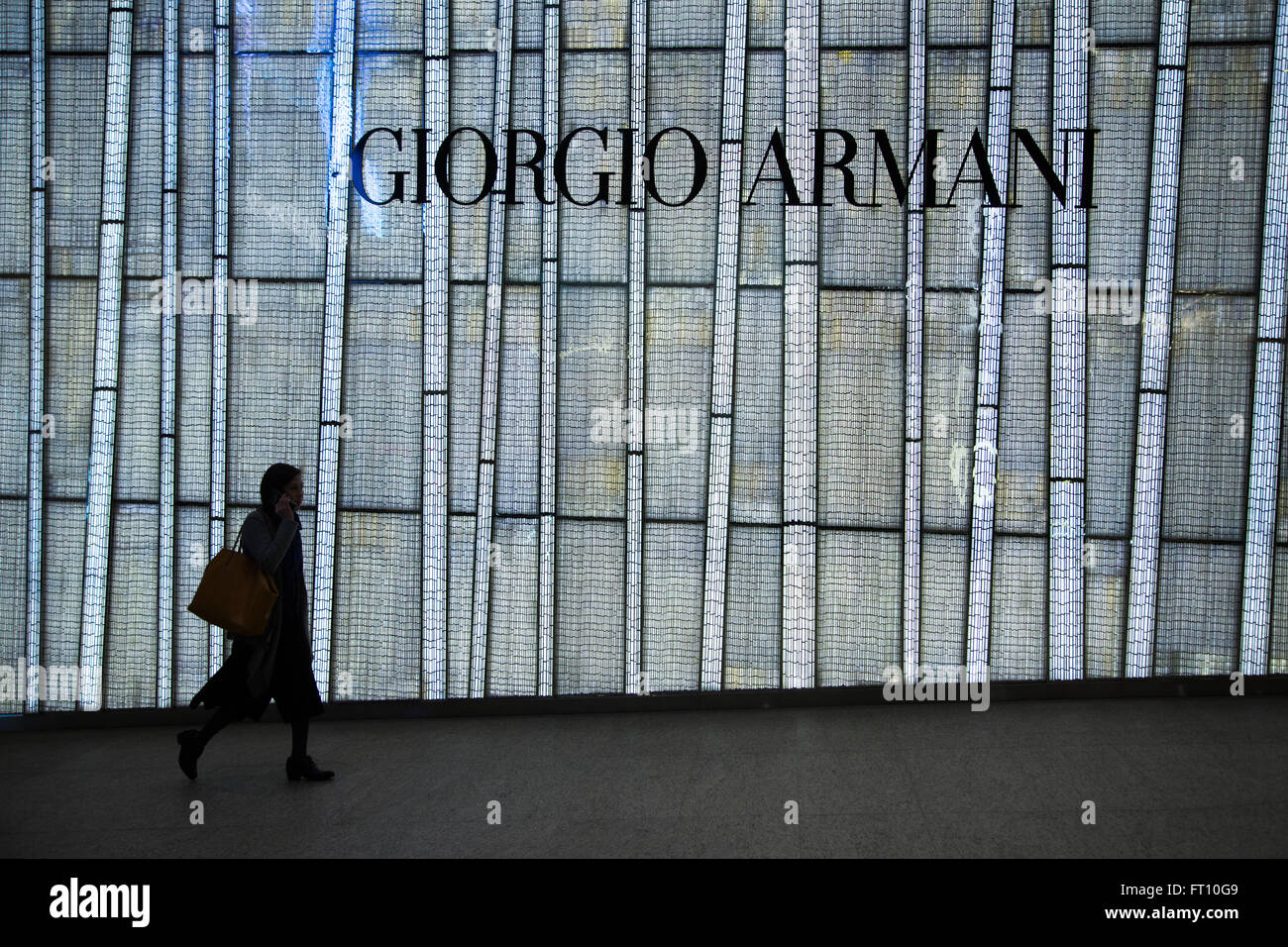 Femme marche en face de Giorgio Armani storefront, Central, Hong Kong Island, Hong Kong Banque D'Images