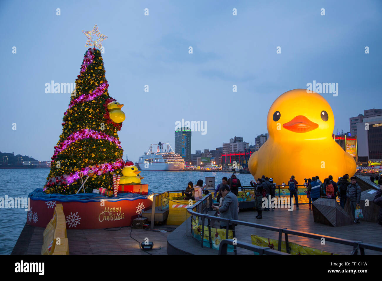 Arbre de Noël et en caoutchouc géant flottant canard sculpture, conçu par l'artiste néerlandais Florentijn Hofman, dans le port de Keelung, au crépuscule, dans le nord de Taiwan, Taiwan Banque D'Images