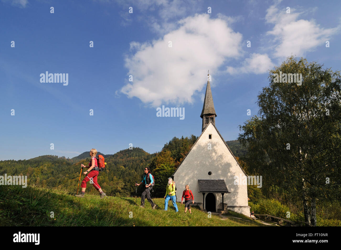Femme Streichenkirche les randonneurs passant, Schleching, Bade-Wurtemberg, Bavière, Allemagne Banque D'Images