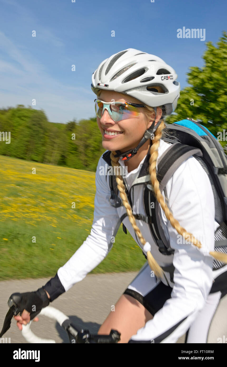 Jeune femme équitation un vélo de course, Haute-Bavière, Allemagne Banque D'Images