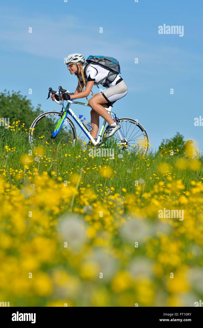 Jeune femme équitation un vélo de course, Haute-Bavière, Allemagne Banque D'Images
