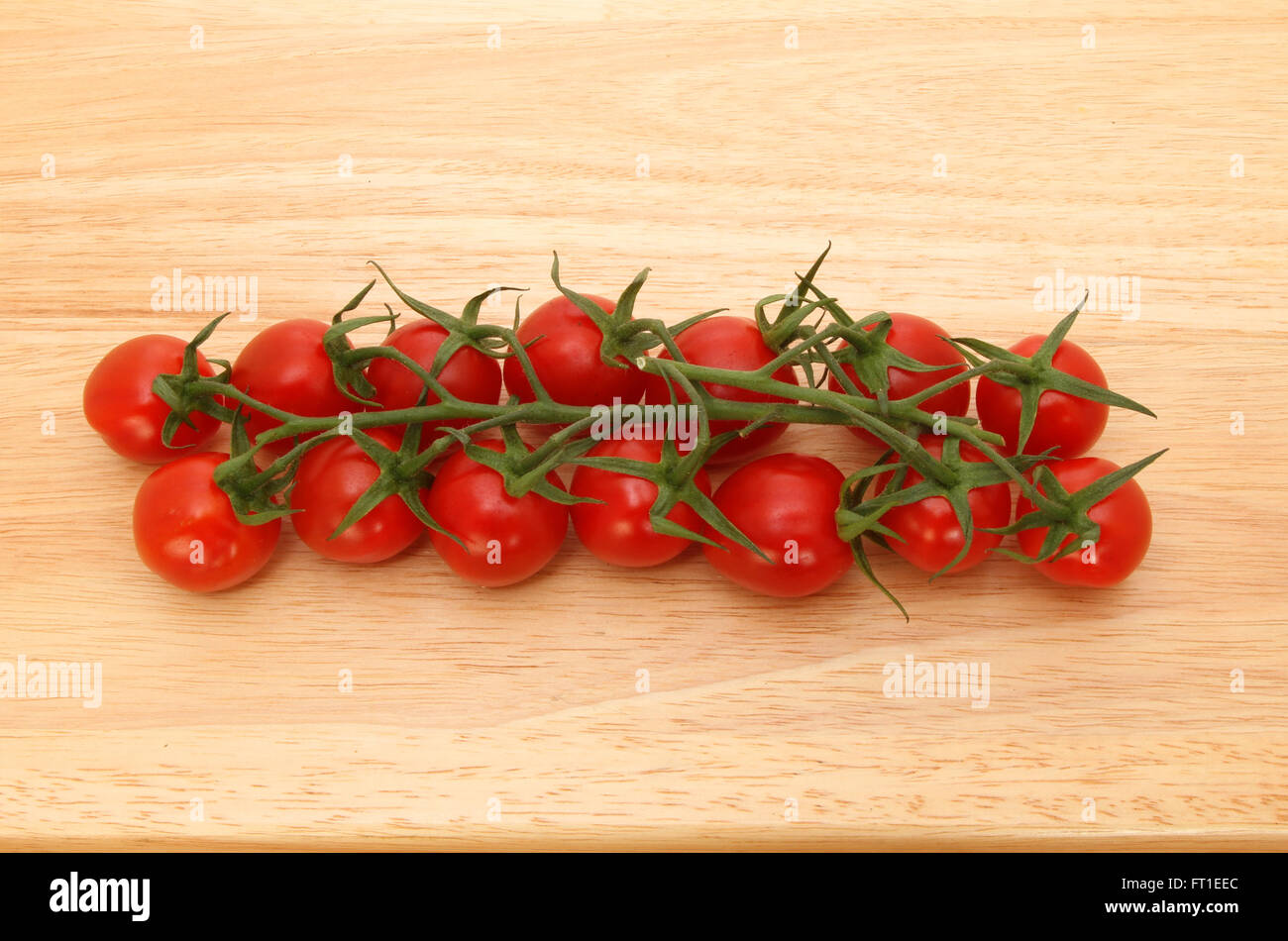 Tomates mûries sur vigne sur une planche en bois Banque D'Images