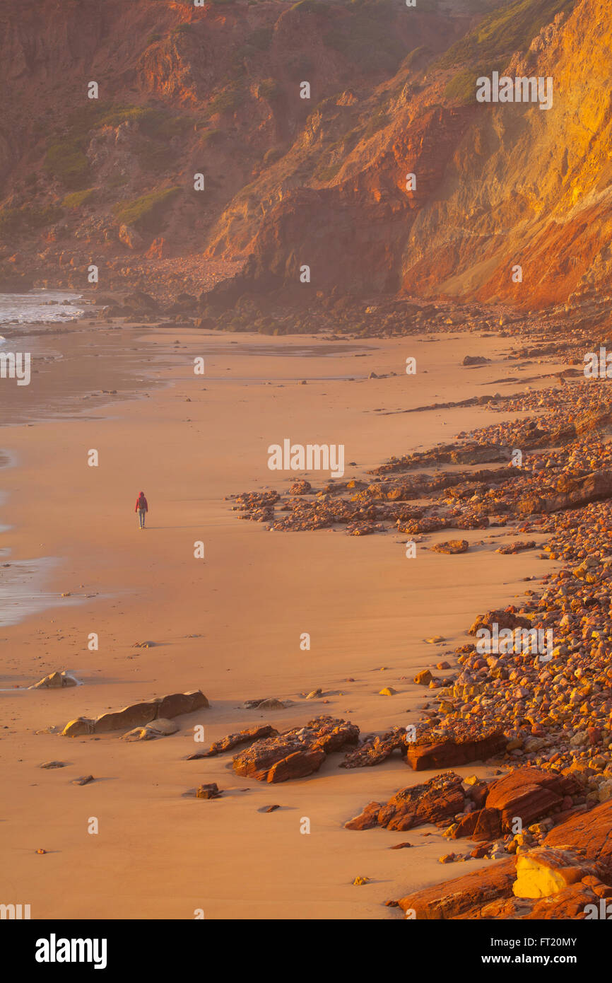 Le magnifique coucher de soleil à la côte du Portugal à l'automne.Seul femme marche sur une plage. Concept de la solitude. Banque D'Images