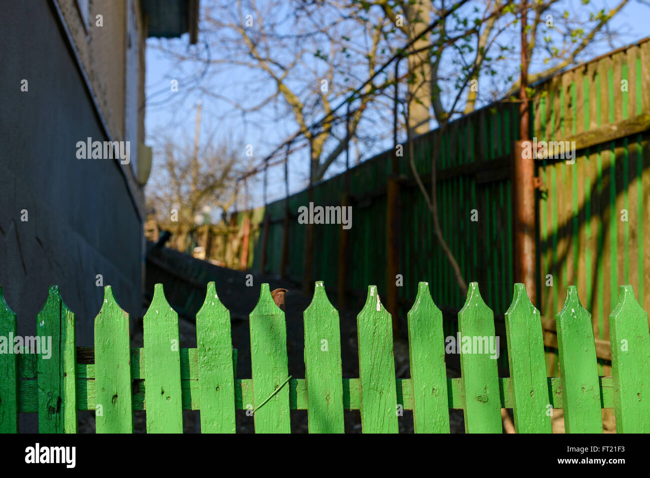 Vieille clôture en bois vert avec la maison en arrière-plan Banque D'Images