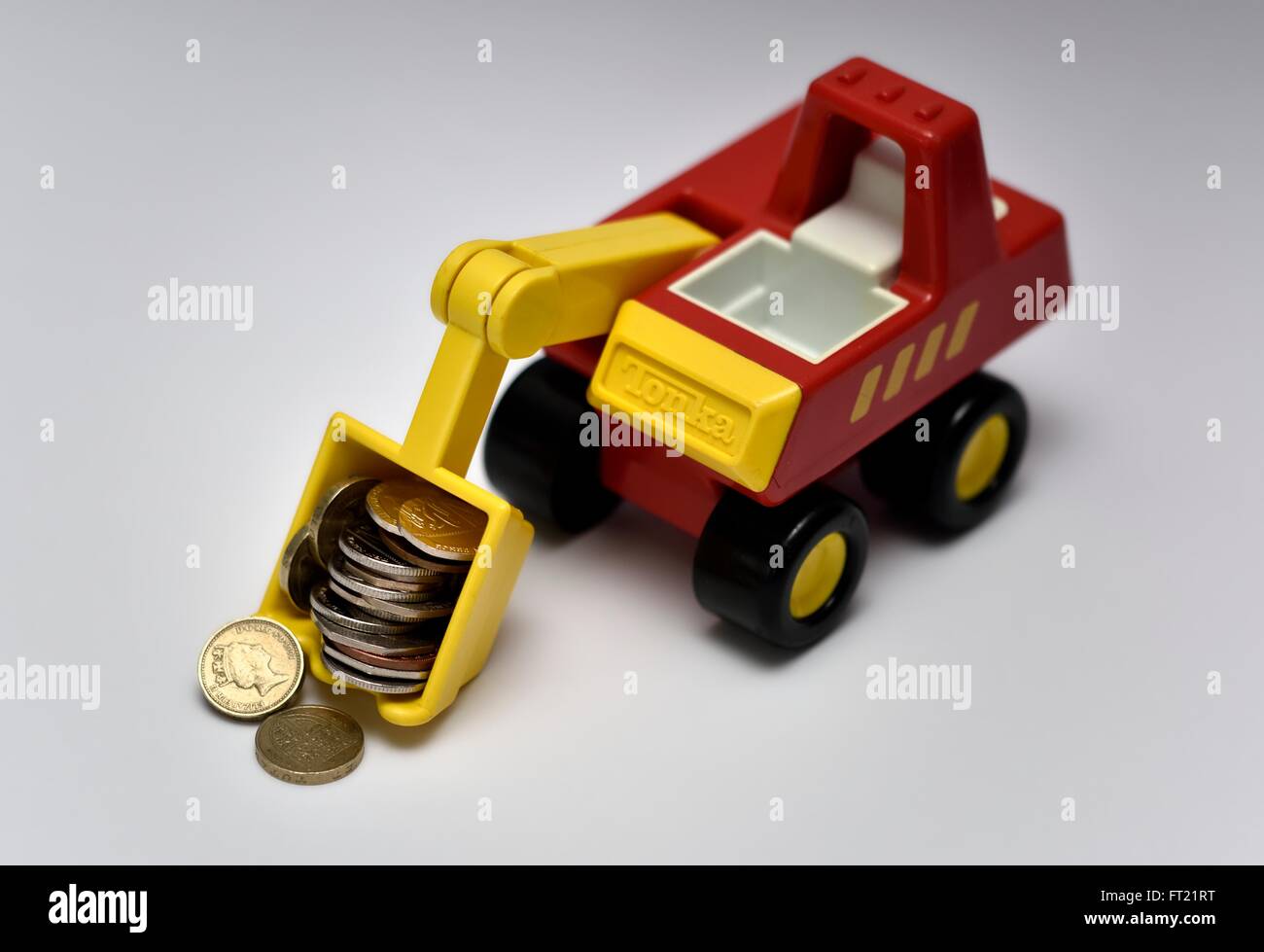 Un jouet digger transportant des pièces de monnaie Banque D'Images