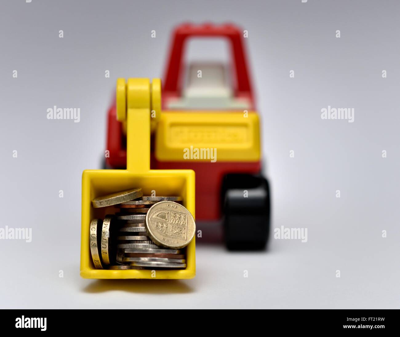 Un jouet digger transportant des pièces de monnaie Banque D'Images