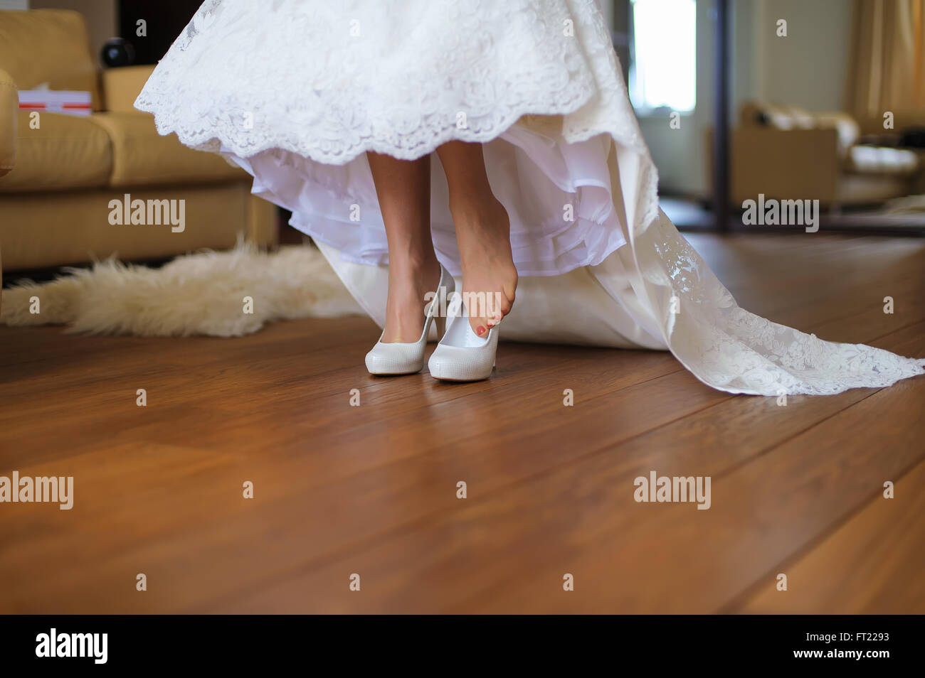 Mariée met sur les chaussures dans la chambre Banque D'Images