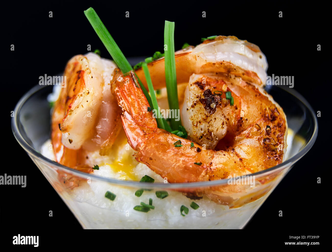 Petite assiette de crevettes et grits dans un verre à martini. Banque D'Images