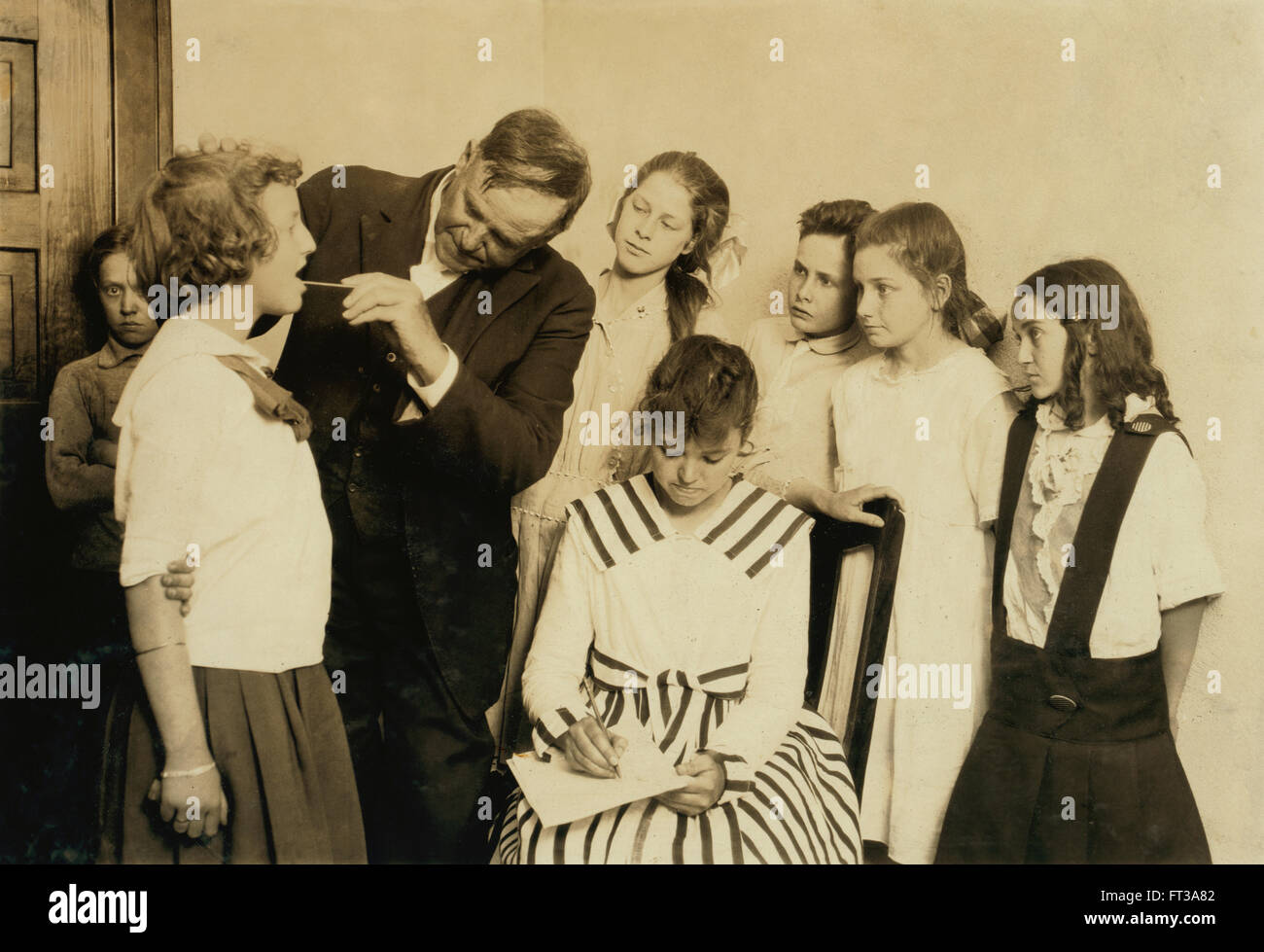 Médecin effectuant l'Inspection médicale et l'examen de la gorge d'enfants en 6 e année, Lawton, Oklahoma, USA, vers 1917 Banque D'Images