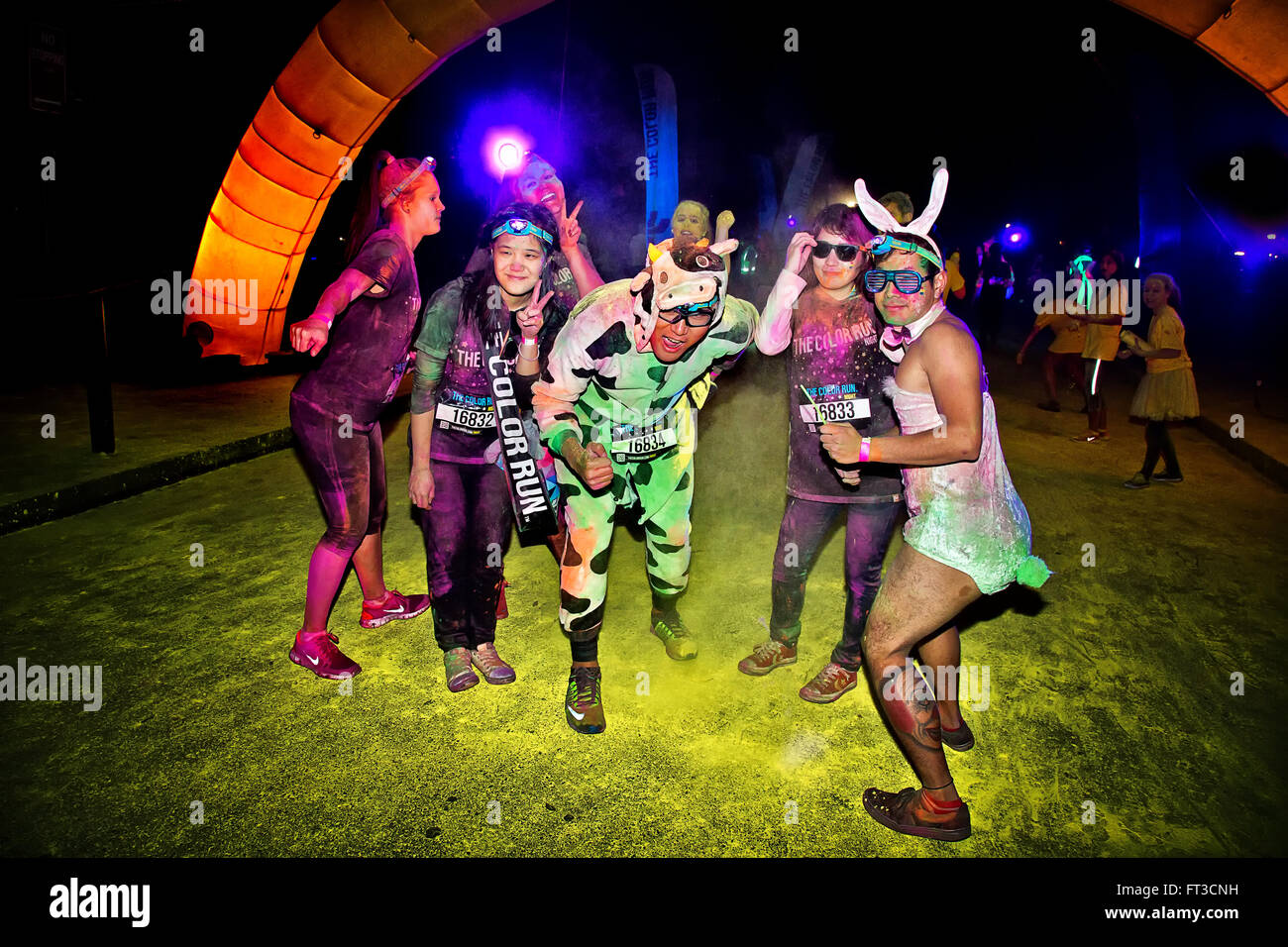 Adultes portant des costumes dans la Color Run nuit 5K fun run. Banque D'Images