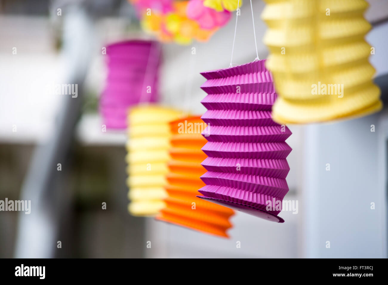 des lanternes de patio en papier aux couleurs vives sont suspendues à une corde dans le jardin pour une fête en plein air. Banque D'Images