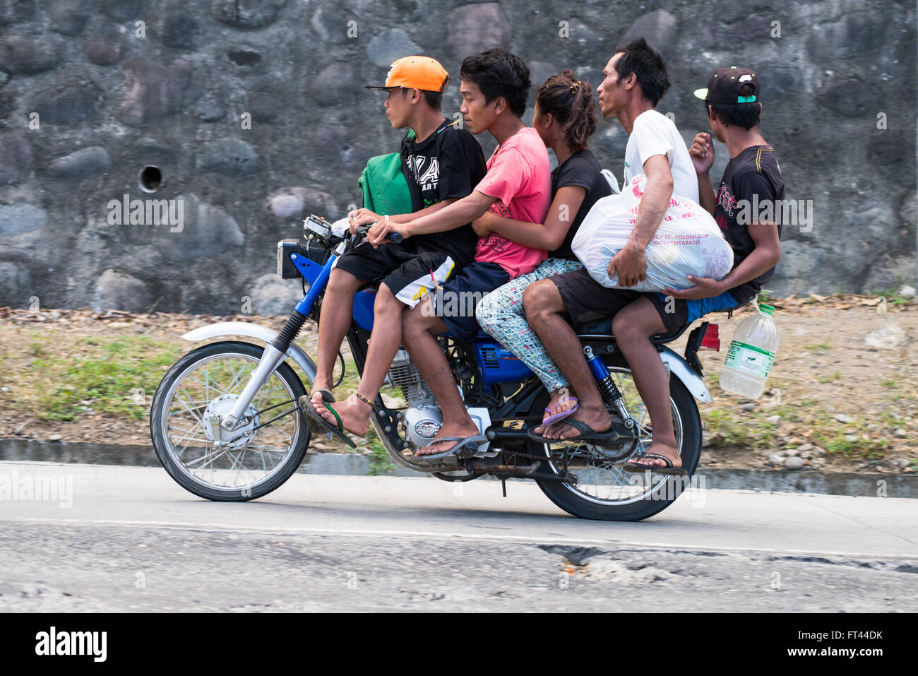 Moto avec cinq personnes sur son chemin jusqu'à une colline entre la ville de Davao et General Santos City aux Philippines. Banque D'Images