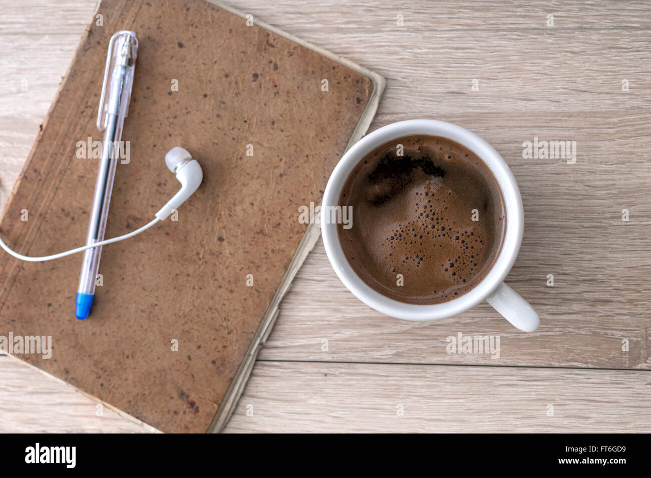 Le café, le bloc-notes, des écouteurs et d'un crayon, sur le bureau. Banque D'Images