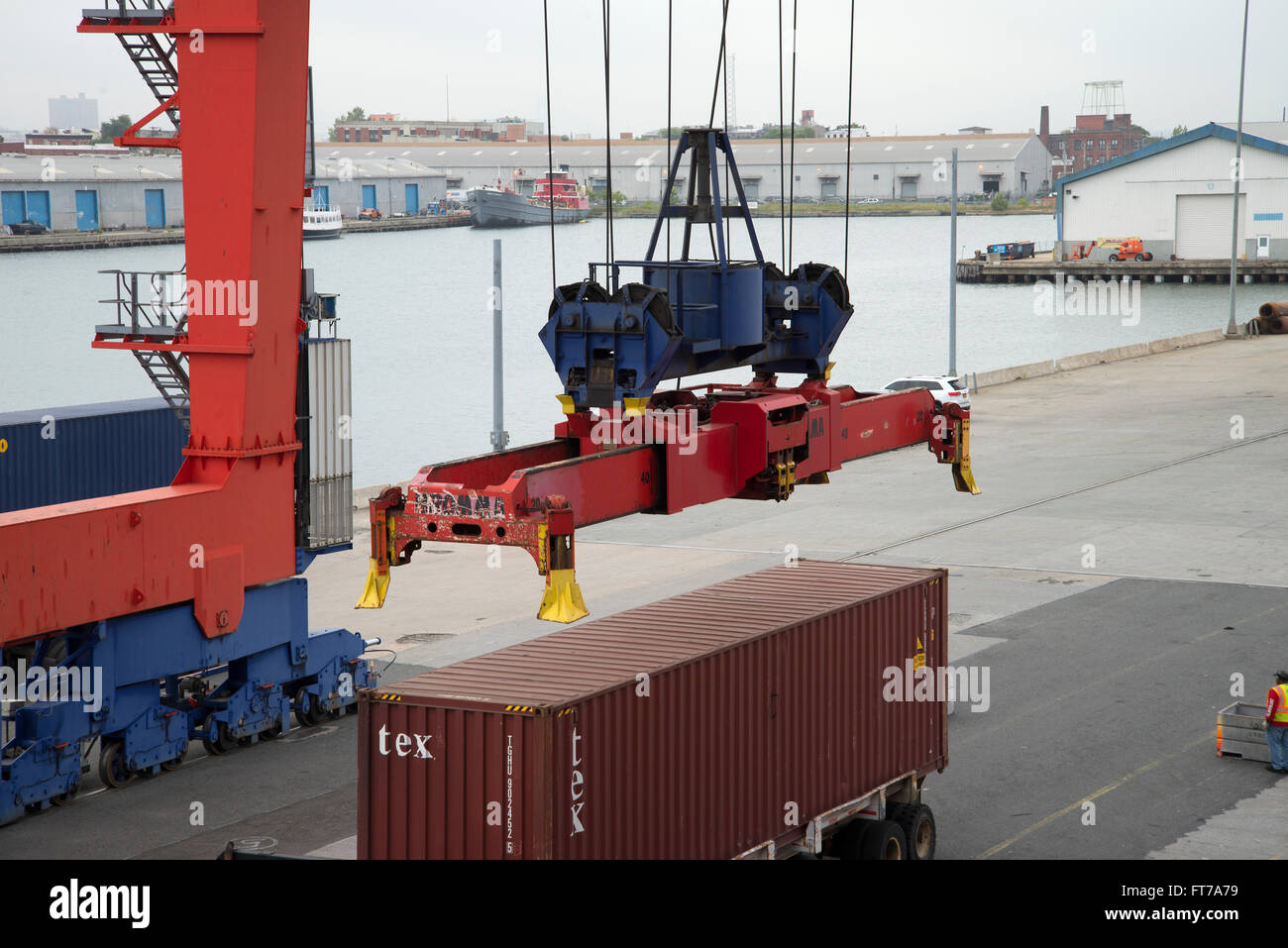 La grue de quai est sur le point de prendre le conteneur lourds déchargés d'un navire porte-conteneurs au port. Banque D'Images