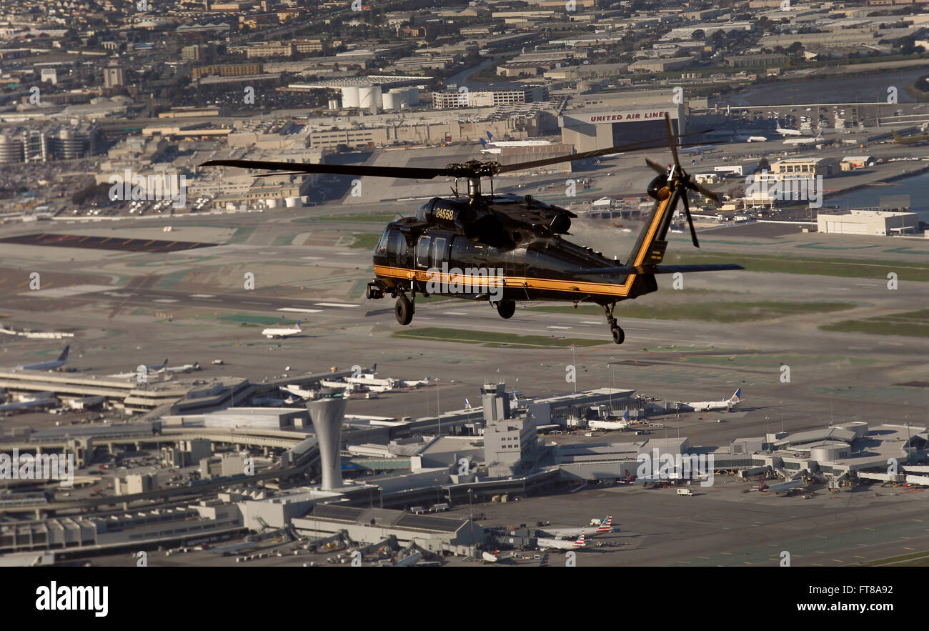 Un U.S. Customs and Border Protection Black Hawk vole au-dessus de l'Aéroport International de San Francisco à San Francisco, Californie, 1 février 2016. (U.S. Customs and Border Protection Photo par Glenn Fawcett) Banque D'Images