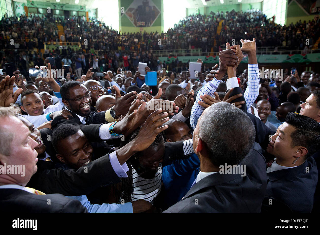 Le 26 juillet 2015, le président Obama a accueilli les membres du public après son discours à la Safaricom Indoor Arena à Nairobi, au Kenya, tandis que les agents des services secrets géraient la foule. L’image capture le moment d’engagement avec le public lors de sa visite. Banque D'Images