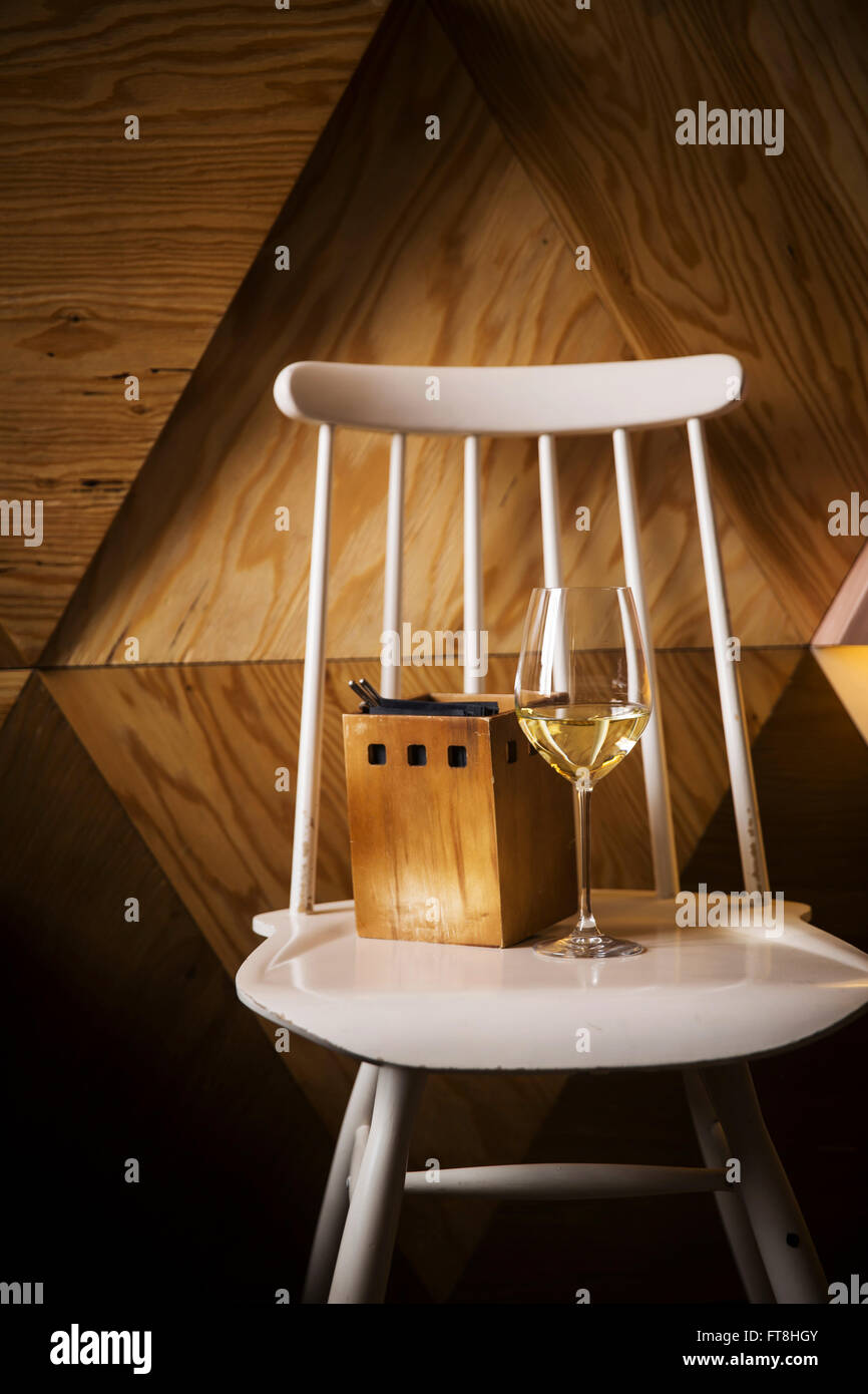 Verre de vin blanc debout sur une chaise vintage Banque D'Images