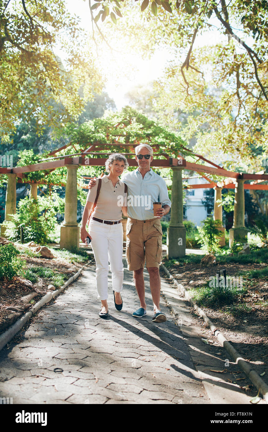 Portrait de senior couple en train de marcher dans un parc. Balades touristiques matures dans un parc de la ville. Banque D'Images