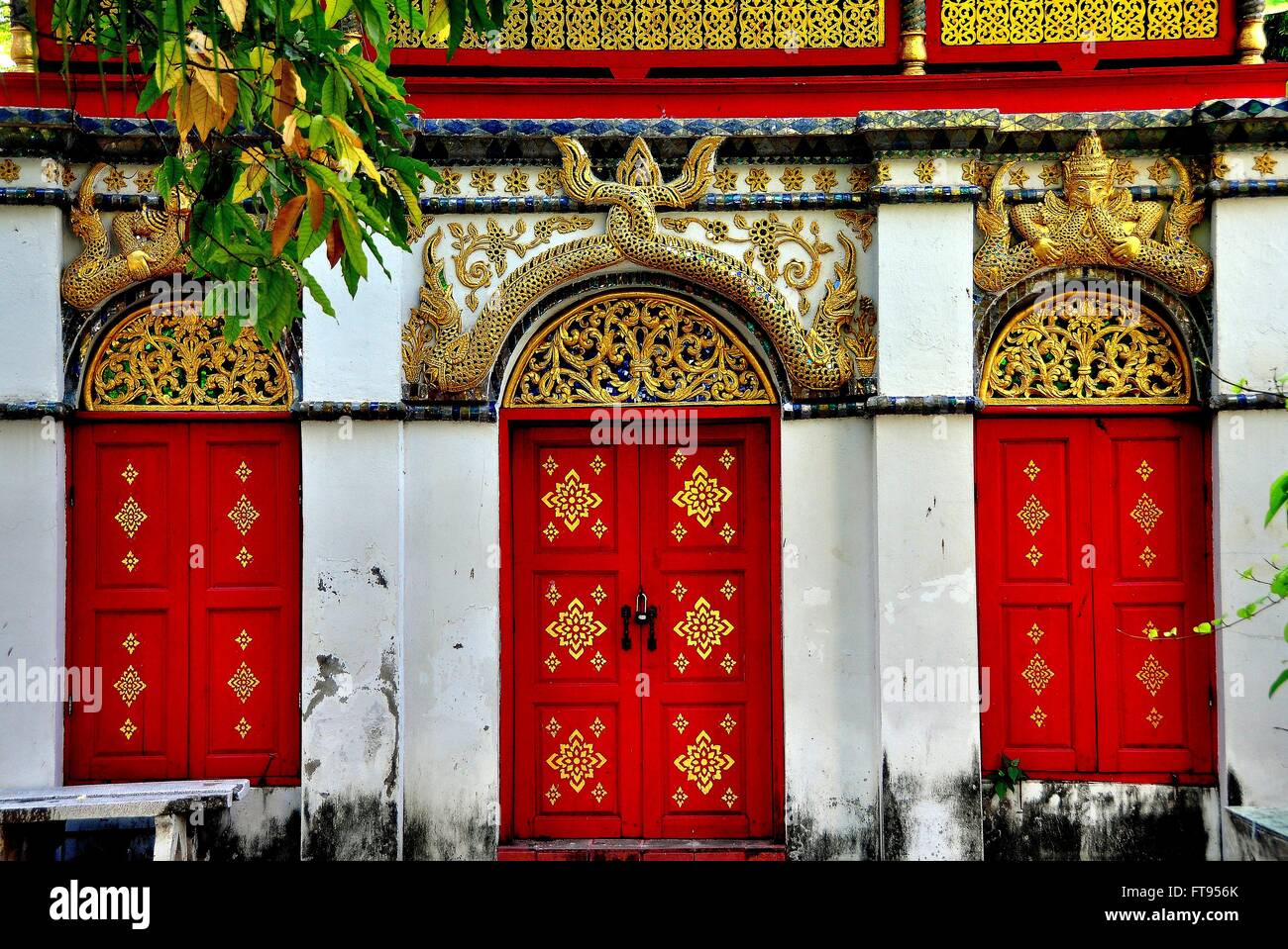 Chiang Mai, Thaïlande : trois portes rouge doré sculpté, avec une queue de dragon et des personnages mythiques ornent à Wat Mulan Banque D'Images