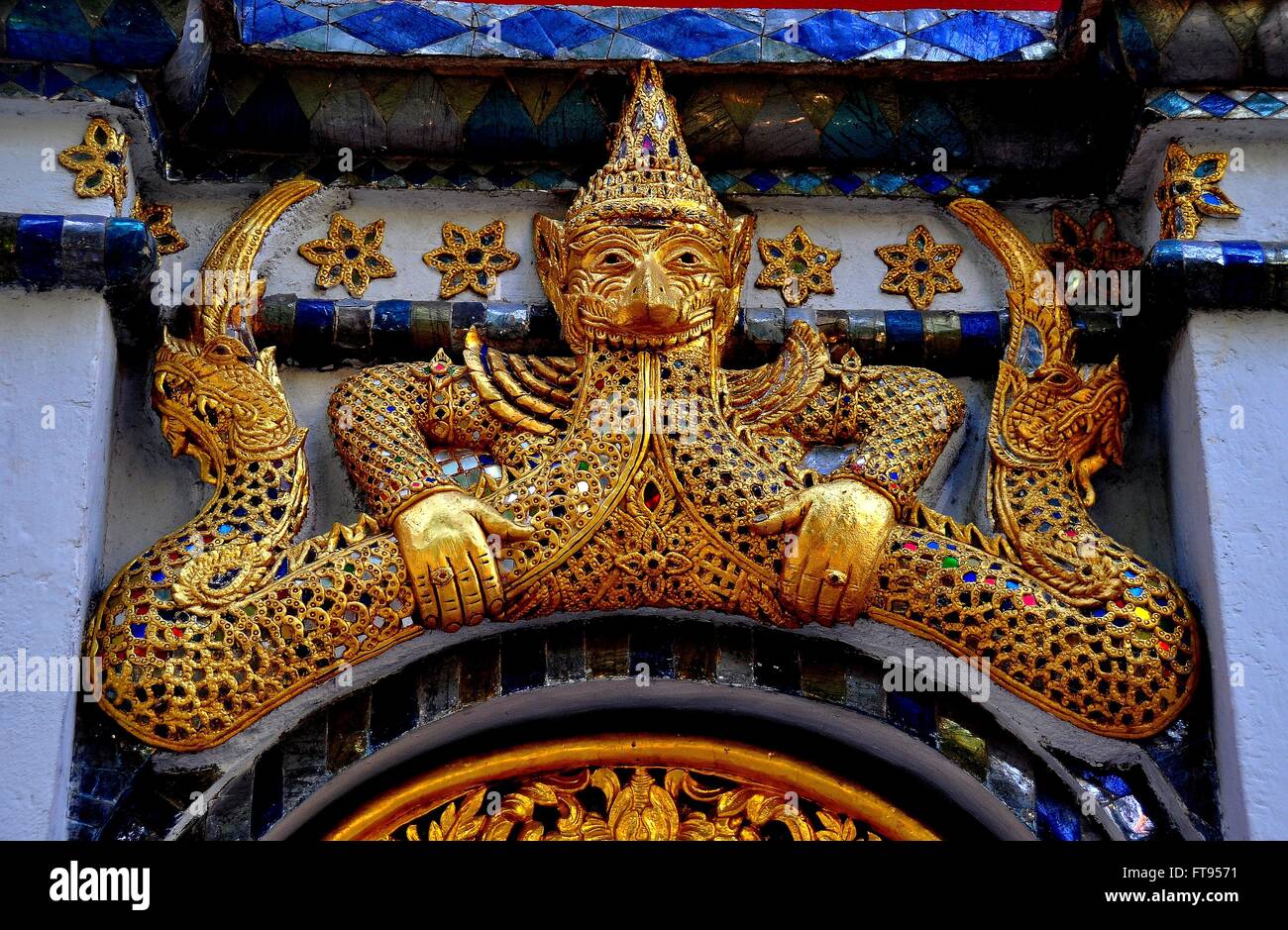 Chiang Mai, Thaïlande : dorées de la figure d'un mi-homme mi-bête flanquée par les dragons ornent une porte au Wat Mulan * Banque D'Images
