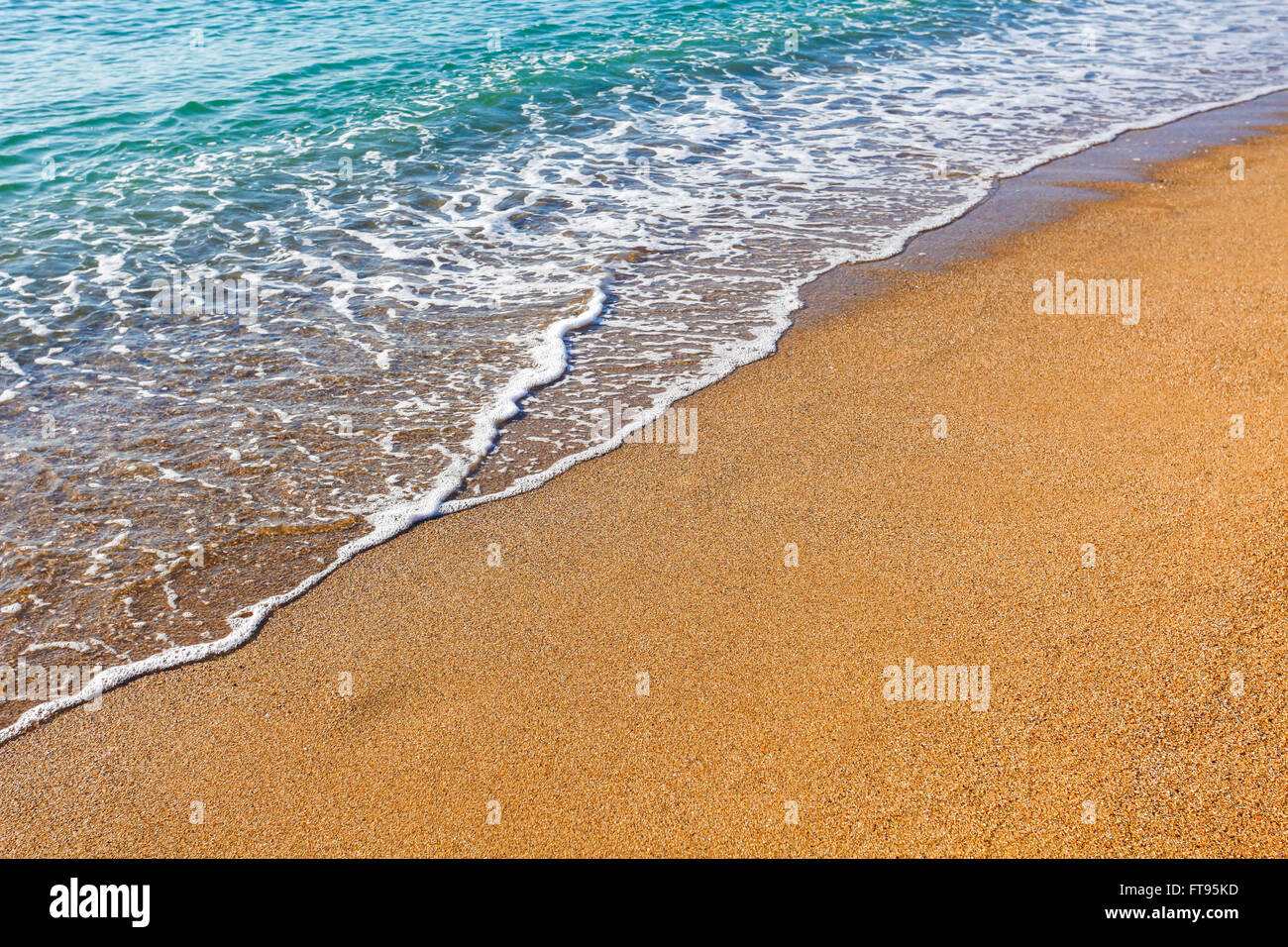 La lumière du soleil reflétée sur l'onde douce sur la plage de sable Banque D'Images