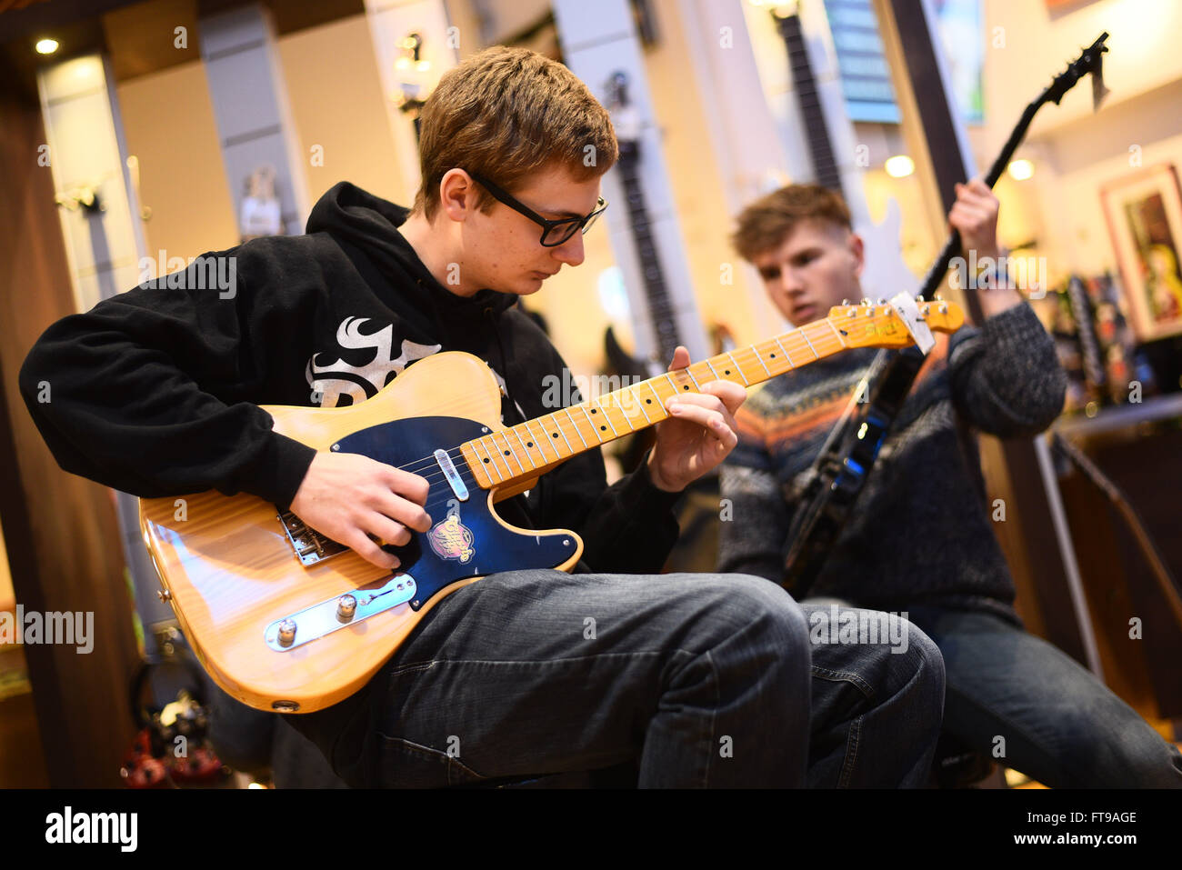 Treppendorf, Allemagne. 24Th Mar, 2016. Musiciens Jonathan (L) et Richard  essayer nouvelles guitares à l'Musikhaus Thomann à Treppendorf, Allemagne,  24 mars 2016. La Musikhaus Thomann est devenu l'un des plus grands  détaillants