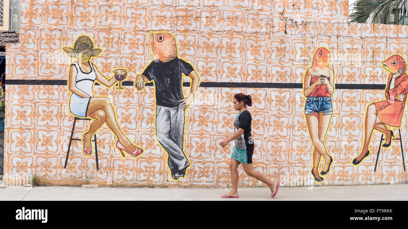 Fish Head murale sur une rue de Tulum. Une femme marche par une grande murale par Emma Rubens se prélasser de gens avec des têtes de poissons inattendue Banque D'Images
