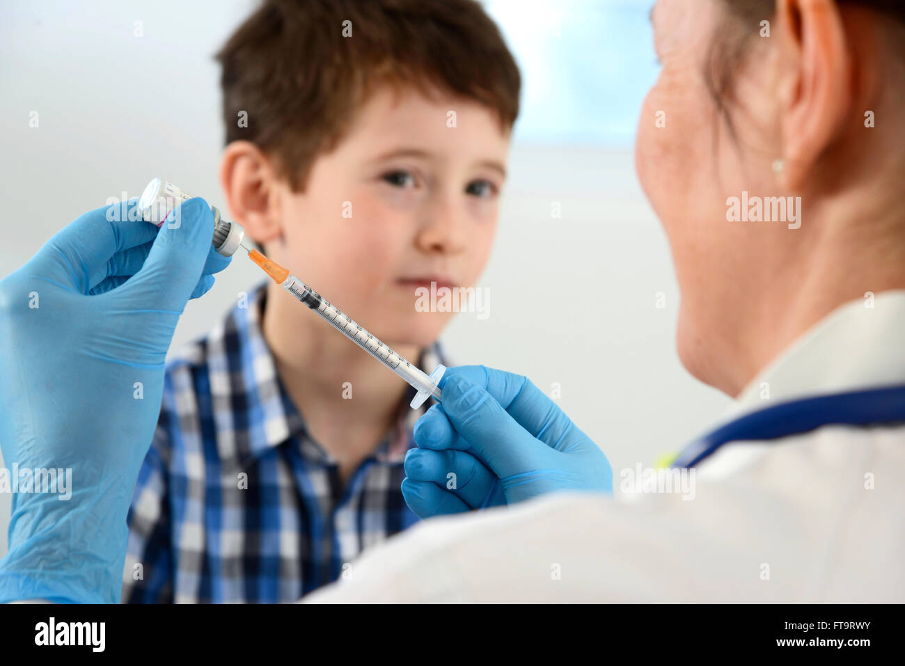 Parution du modèle. Pratique générale médecin donnant un jeune garçon dans une clinique de vaccination. Banque D'Images