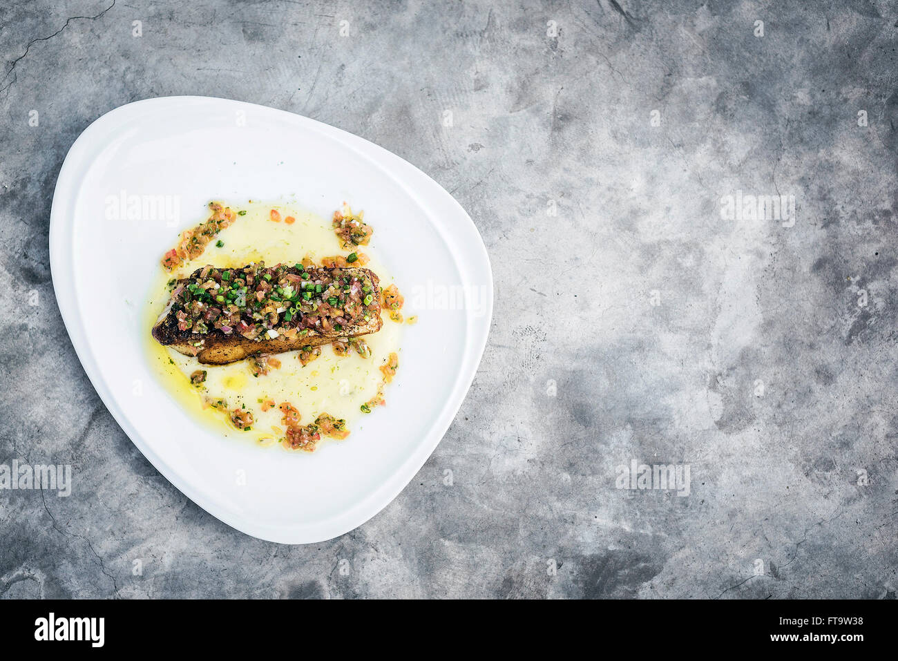 Sea Bass poisson avec sauce salsa mexicaine oignon tomate Banque D'Images