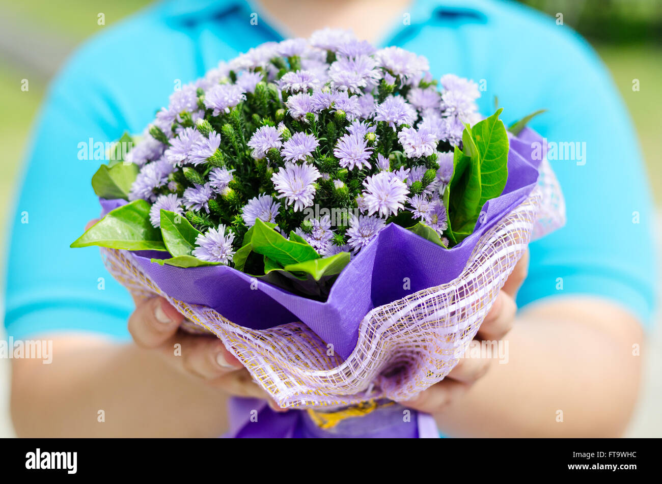 Portrait of a man holding bouquet de fleurs violettes. Banque D'Images