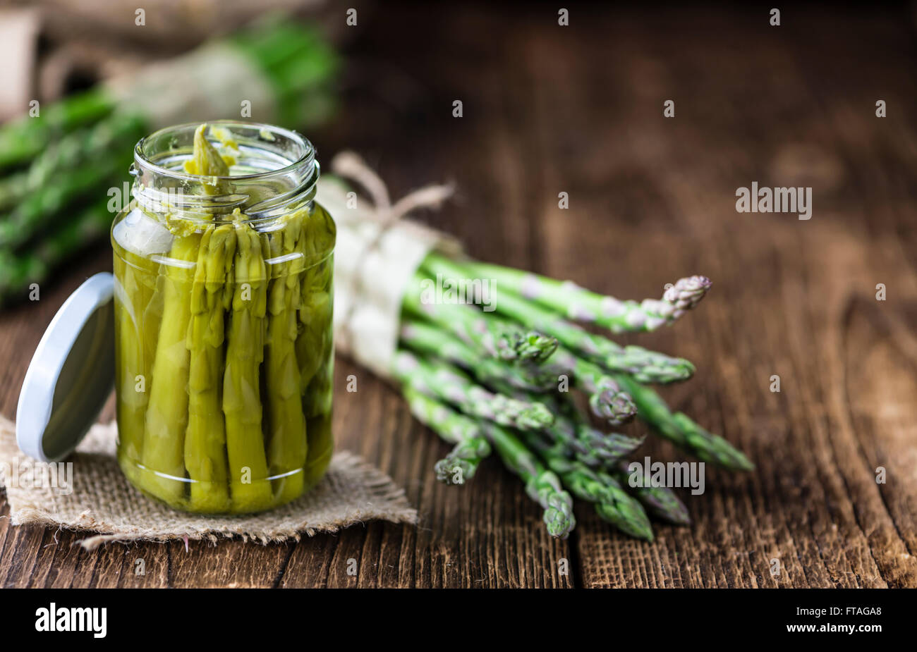 L'asperge verte préservée (selective focus) sur fond de bois Banque D'Images