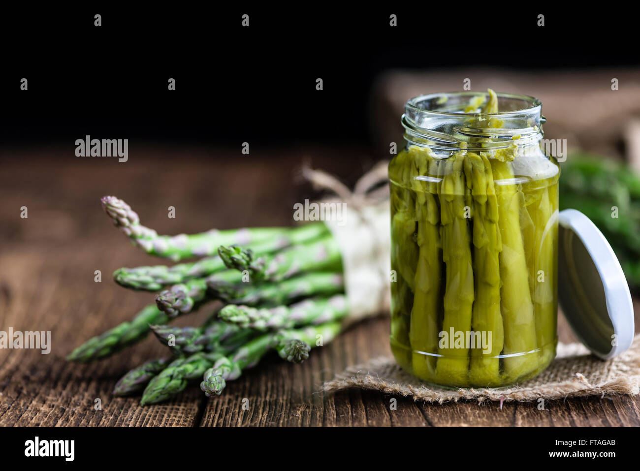 L'asperge verte (conservé) sur une vieille table en bois (selective focus) Banque D'Images