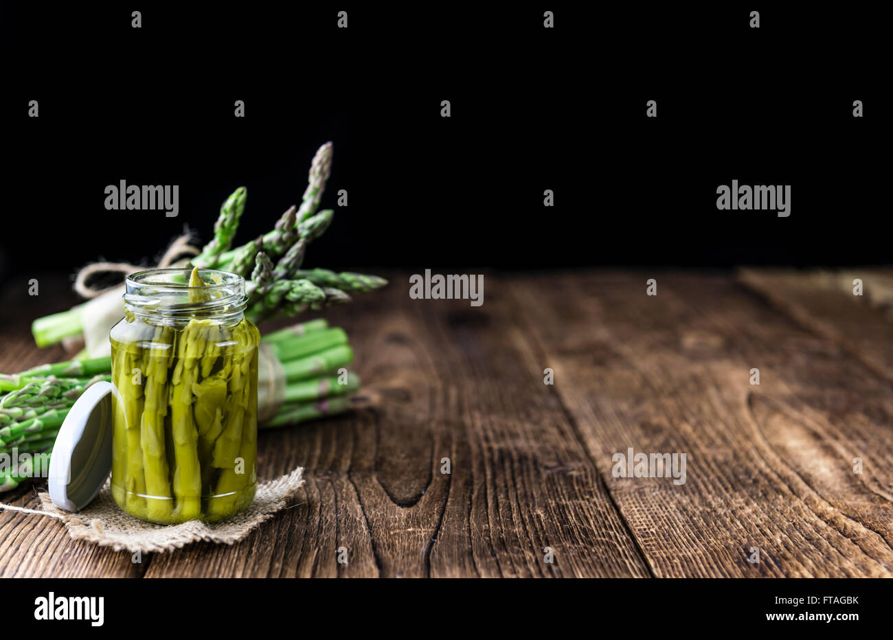 L'asperge verte préservée (selective focus) sur fond de bois Banque D'Images
